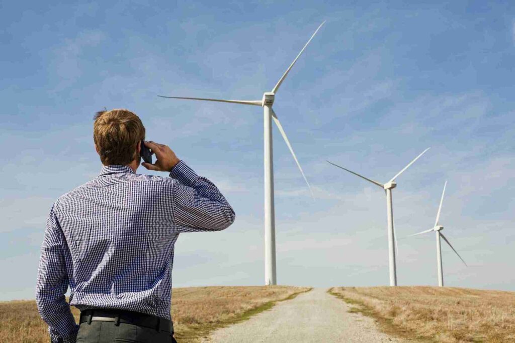 businessman-on-a-call-overlooking-wind-turbines-in-2024-05-29-02-50-25-utc-min-scaled-1_11zon
