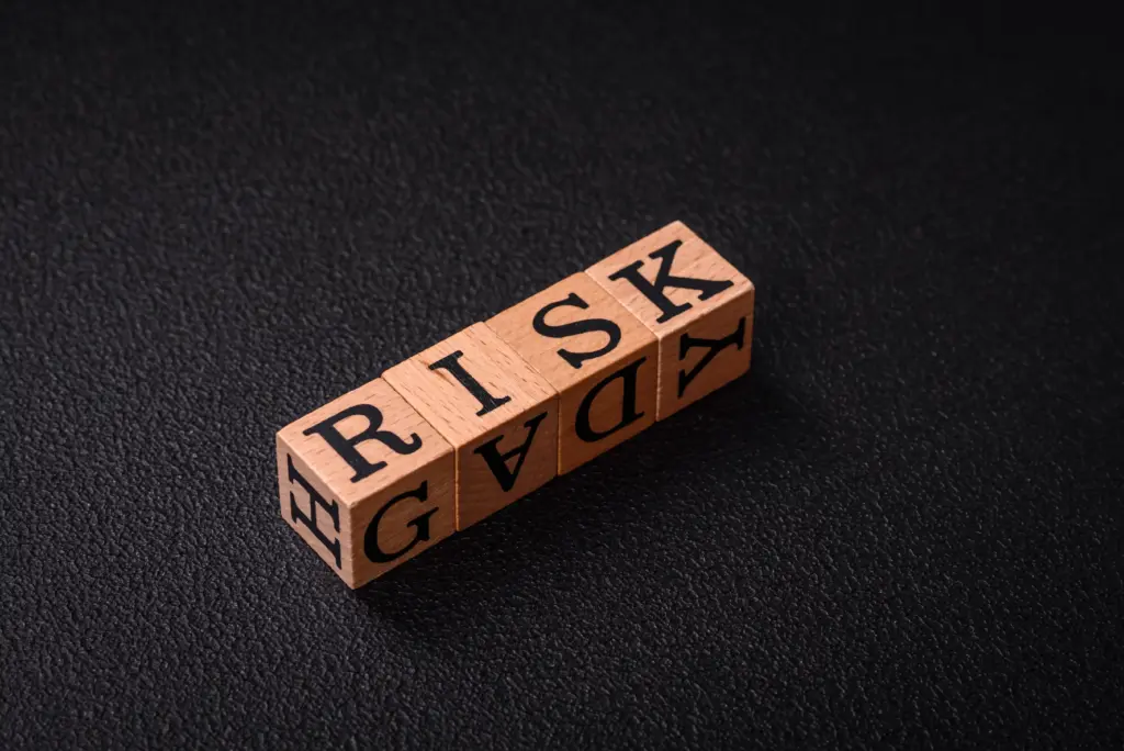 Forex Risk Management Strategies concept shown with wooden blocks spelling “RISK” on dark surface.