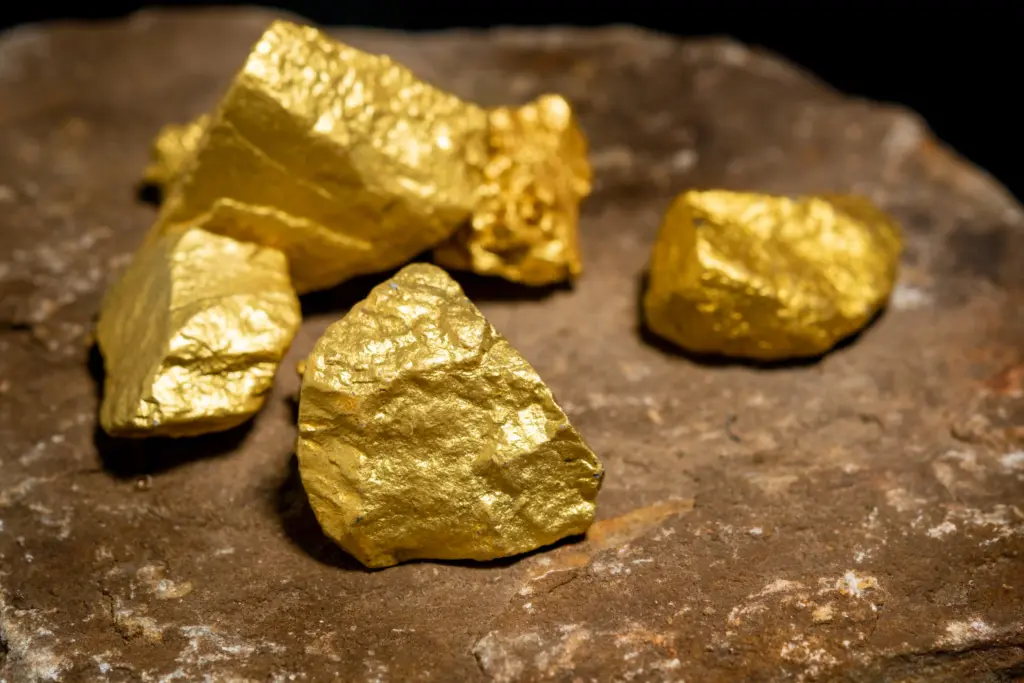 Gold nuggets on a rock surface symbolizing pure investment value for traders exploring how to buy gold in 2026.
